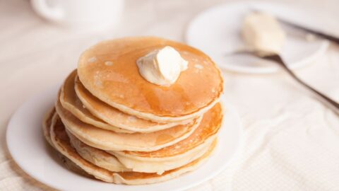 stapel pannenkoeken met boter beige achtergrond op wit servies