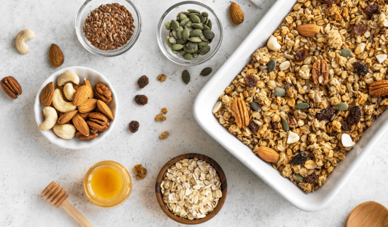 plaat vegan granola met bakjes ingrediënten op neutrale achtergrond